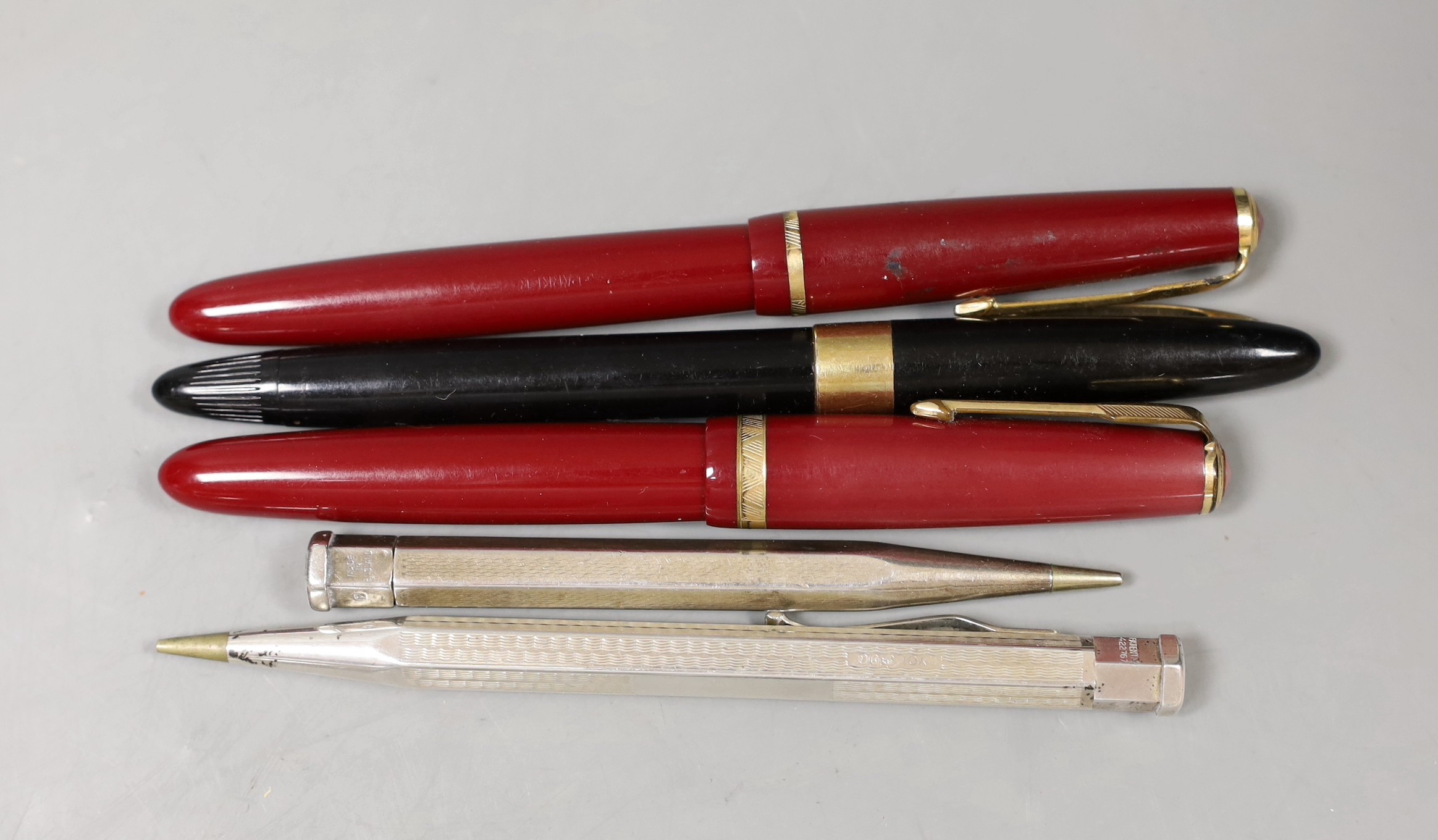 Two Parker fountain pens including Junior and three other pens or pencils including two silver cased.